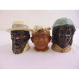 Three 19th century ceramic tobacco jars, in the form of African figurines one with the impressed
