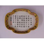 A Chinese shaped rectangular porcelain dish with floral border and Chinese characters to the centre
