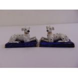 A pair of Staffordshire style Dalmatian porcelain figurines on raised rectangular bases