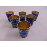 A set of six Russian white metal and cloisonne‚ vodka tots decorated with stylised leaves and