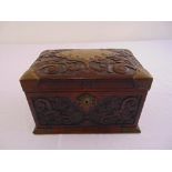 An early 20th century carved wooden jewellery casket rectangular with brass handles, escutcheon