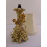 A continental porcelain table lamp formed as figures in a classical myth with silk shade