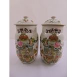 A pair of Chinese cylindrical vases with pull off covers decorated with flowers, vases and