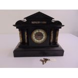 A French black marble mantle clock of architectural form to include key and pendulum