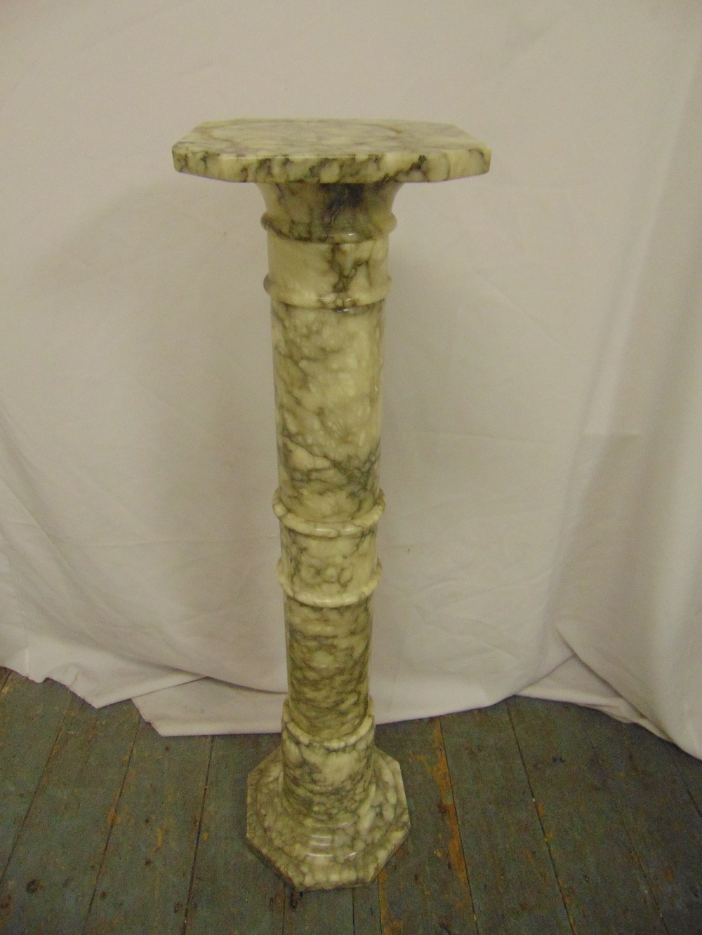 A marble column plant stand of ribbed cylindrical form with octagonal top and base