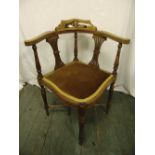 An Edwardian mahogany corner chair with pierced slats on four turned legs
