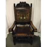 An antique Spanish walnut throne, heavily carved and with embossed coloured seat and back,