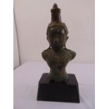An antique South East Asian bronze bust of a female figure on carved rectangular wooden base,