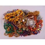A quantity of costume jewellery to include necklaces, bangles and some amber necklaces