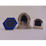 A hexagonal white metal and blue enamel photograph frame and two white metal photograph frames of