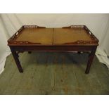 A Chinese style rectangular coffee table with pierced gallery and leather top opening to reveal a