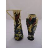 A Moorcroft jug and matching vase decorated with lilies and bull rushes, marks to the bases, 24cm (