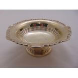 A silver bowl with scroll border, ribbed sides on raised circular foot, Sheffield 1946 by Walker and