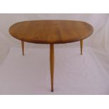 A mid 20th century Ercol elm occasional table of oval form on three oval shaped legs