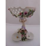A Sitzendorf porcelain comport on stand decorated with a figurine holding a basket kneeling on a