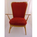 A mid 20th century Ercol elm armchair with upholstered back and seat on four tapering tubular legs