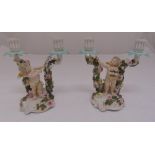 A pair of Sitzendorf two branch candelabra with applied putti figurines and flowers, marks to the