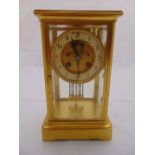 A brass four glass mantle clock of rectangular form with circular dial, Arabic numerals all on