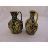 A pair of Cantagalli Majolica jugs decorated in the William Morris style with infants, monkeys and