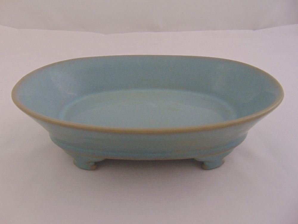 A Chinese Song style Ruware celadon oval shaped dish on four bracket feet, marks to the base, 7cm (