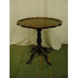 A mahogany wine table with moulded border, baluster stem and four scroll legs