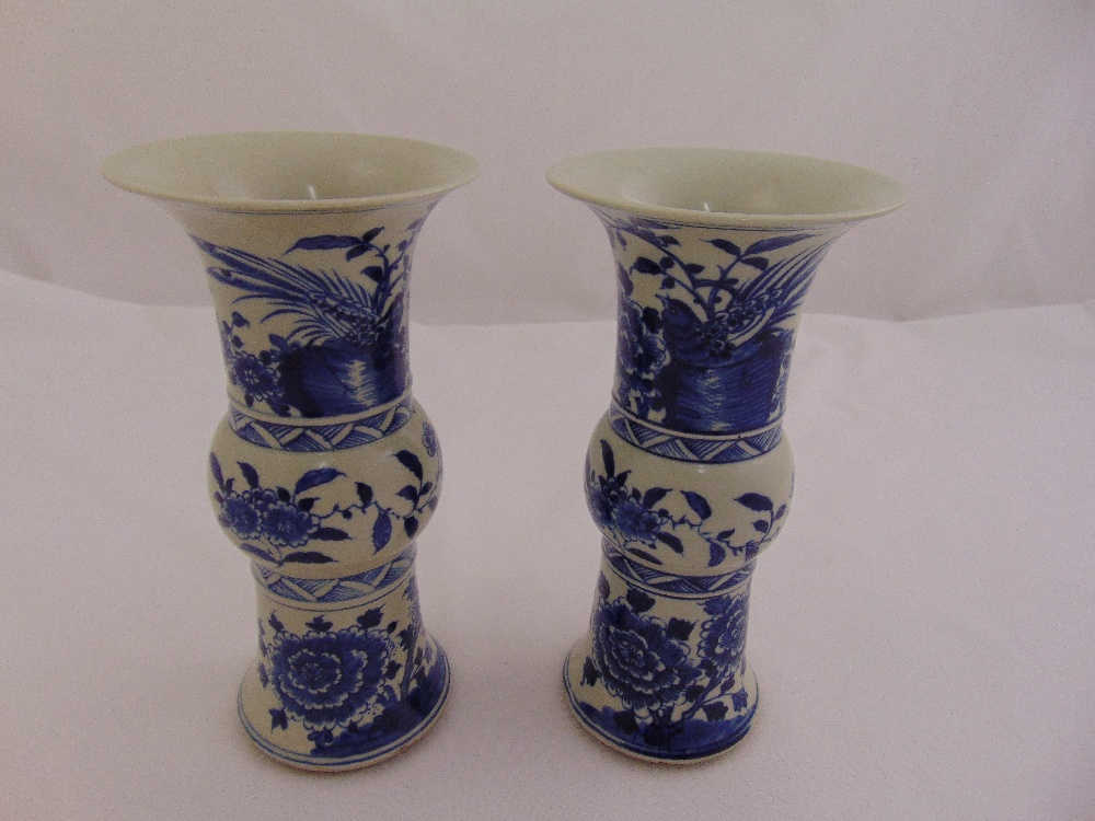 A pair of Chinese blue and white vases of waisted cylindrical form decorated with flowers and