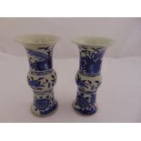 A pair of Chinese blue and white vases of waisted cylindrical form decorated with flowers and
