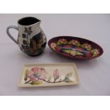 A Moorcroft milk jug, an oval bowl and pin tray, marks to the bases, 14.5cm (h)