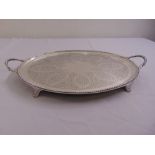 A Victorian silver tea tray, oval engraved to the centre with leaves scrolls and flowers with beaded