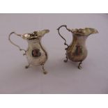 A George II silver cream jug pear shaped with double scroll handle on three scroll legs London