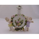 A Sitzendorf porcelain decanter with stopper decorated with applied putti and floral decorations,