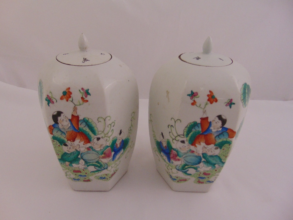 A pair of Chinese famile verte ginger jars with pull off covers, the sides decorated with children