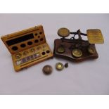 A set of brass and wooden postal scales and a cased set of weights plus others