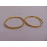 A pair of 20ct yellow and white gold bangles stamped 875, approx total weight 27.2g