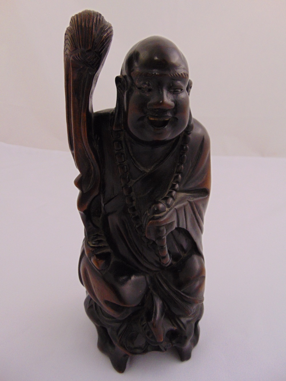 Chinese hardwood carving of a Buddha holding a staff, 23cm (h)
