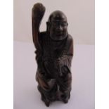 Chinese hardwood carving of a Buddha holding a staff, 23cm (h)