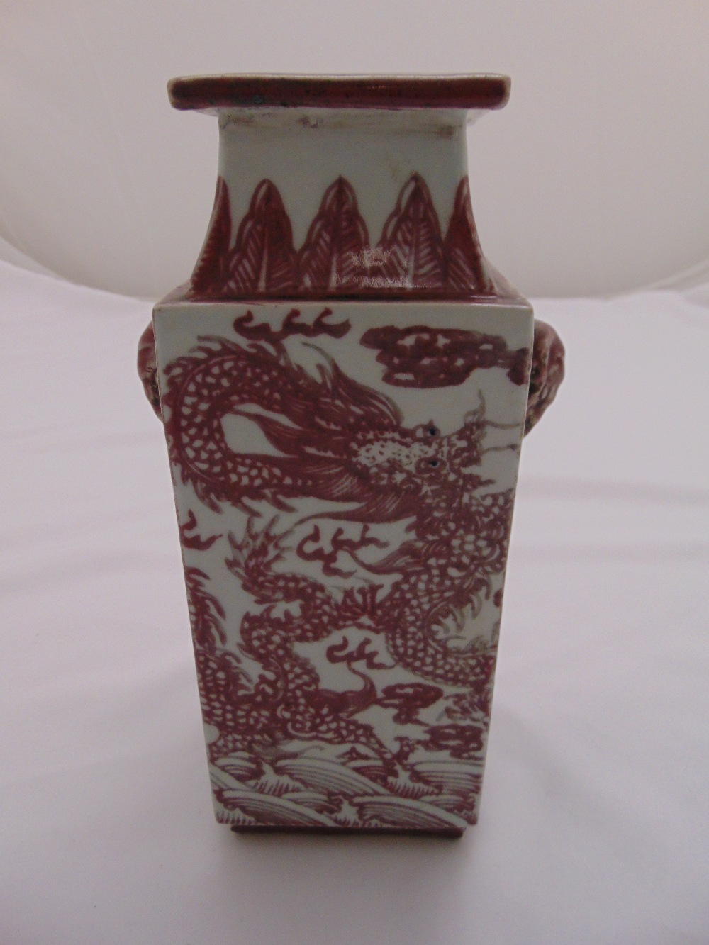 A Chinese rectangular vase with elephant mask side handles, decorated with dragons and bats, 26cm (