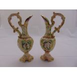 A pair of Capodimonte decorative ewers of classical form with pierced scroll handles on raised