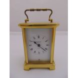 A Bayard brass carriage clock of customary form with white enamel dial and Roman numerals to include