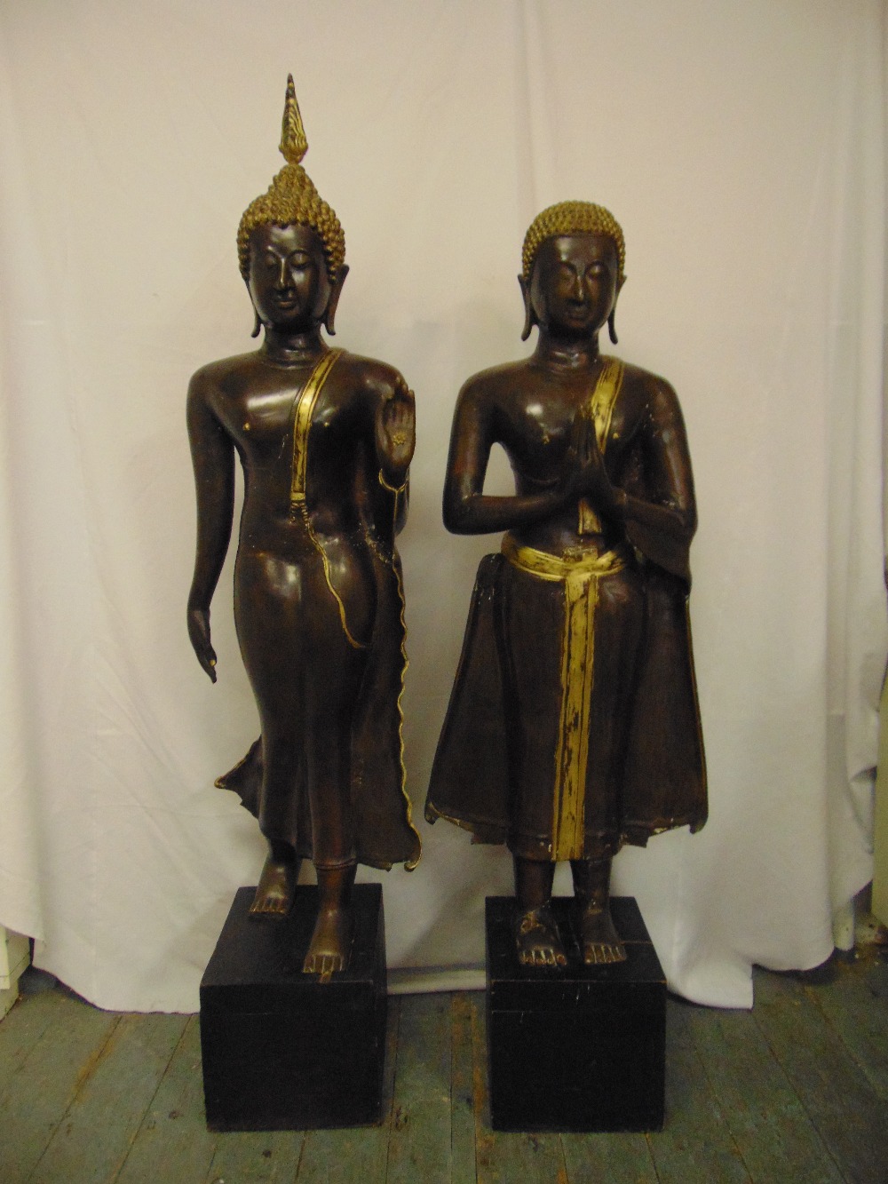 Two early 20th century cast bronze Thai figures highlighted with gilt wash on rectangular base, a.