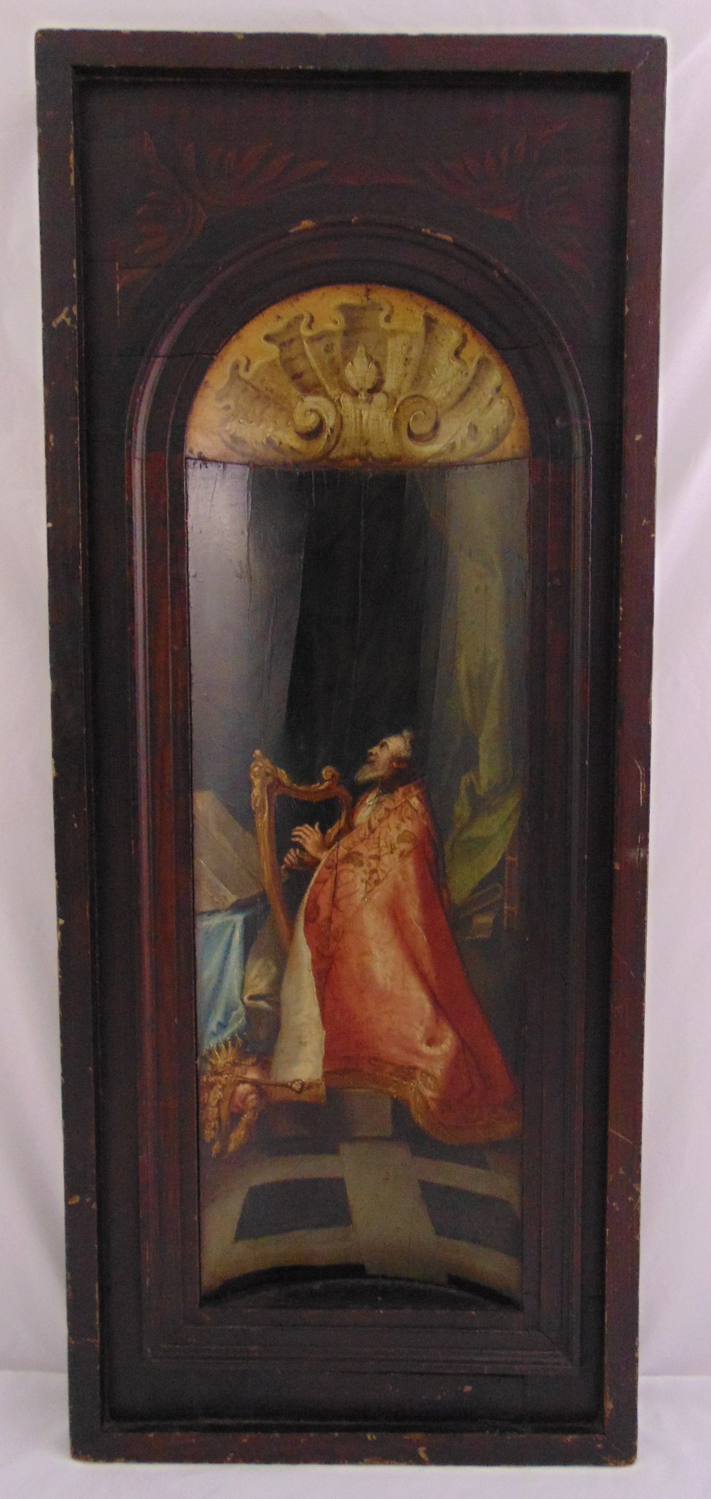 An 18th century continental oil on canvas of a religious figure playing a harp within a curved