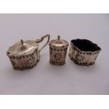 A silver three piece condiment set pierced sides with detachable blue glass liners, Birmingham