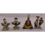 Four continental figurines to include a seated gentleman, a figural group of a boy and girl carrying