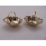 A pair of Victorian silver bonbon baskets with scroll handle and crimped edges, London 1883 by