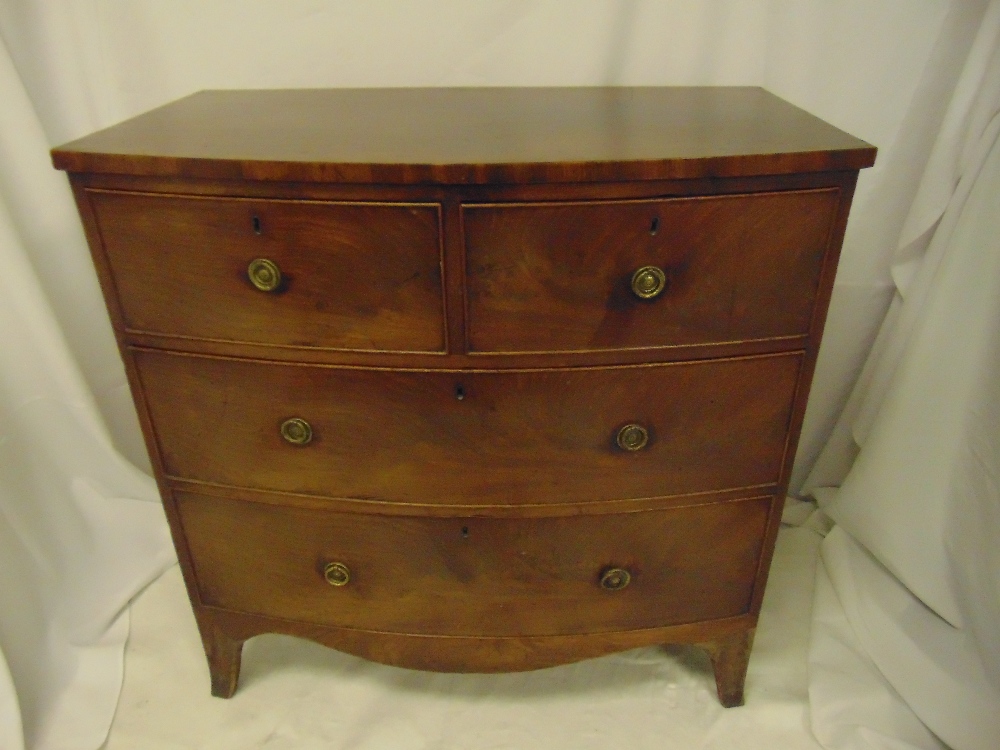 An early 19th century mahogany bow fronted chest of drawers with brass handles on four bracket feet