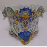 A Majolica pierced cylindrical jardinière decorated with flowers, scrolls and mask side handles,