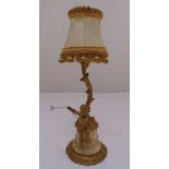 A gilded metal lamp stand in the form of a putti beneath a tree on raised circular plinth, A/F to