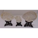 Three oriental Mother of Pearl shells on carved hardwood stands