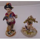 Two Sitzendorf figurines, to include a figurine of a boy in 18th century attire holding a turkey,