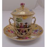 A continental chocolate cup, saucer and cover, decorated with courting couples, the raised pull of